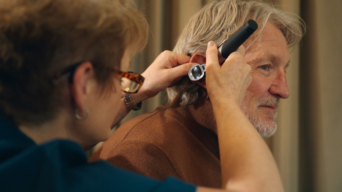 Russell Osman having his ears checked by All About Hearing audiologist and co-director, Karen Finch